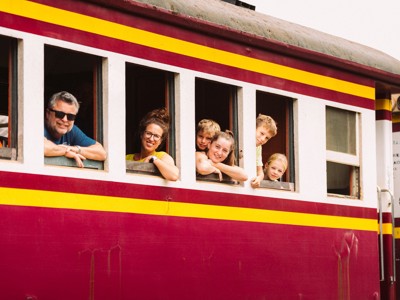 Gezin leunt uit de ramen van een trein tijdens de Route Thailand Noord en Zuid.
