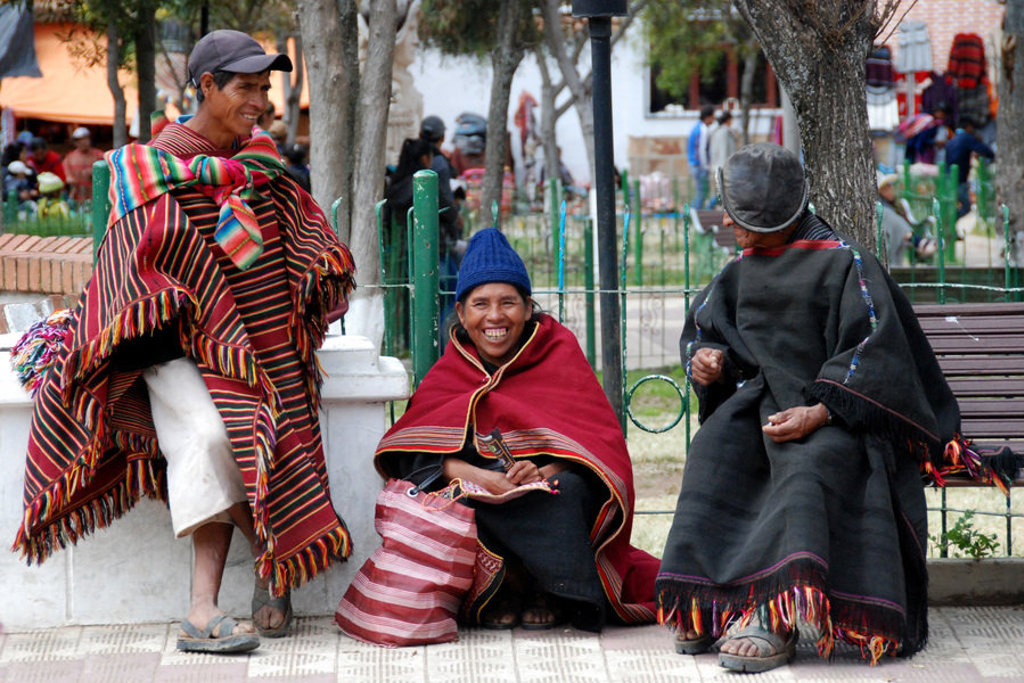 Lokale bewoners in traditionele kleding op een plein tijdens een groepsrondreis door Bolivia en Chili.