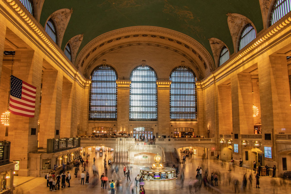 Grand Central Terminal in New York met de iconische hal, Amerikaanse vlag en reizigers.