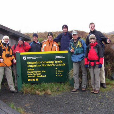 Groepsrondreis Nieuw-Zeeland: wandelaars bij het bord van de Tongariro Crossing in Tongariro National Park.