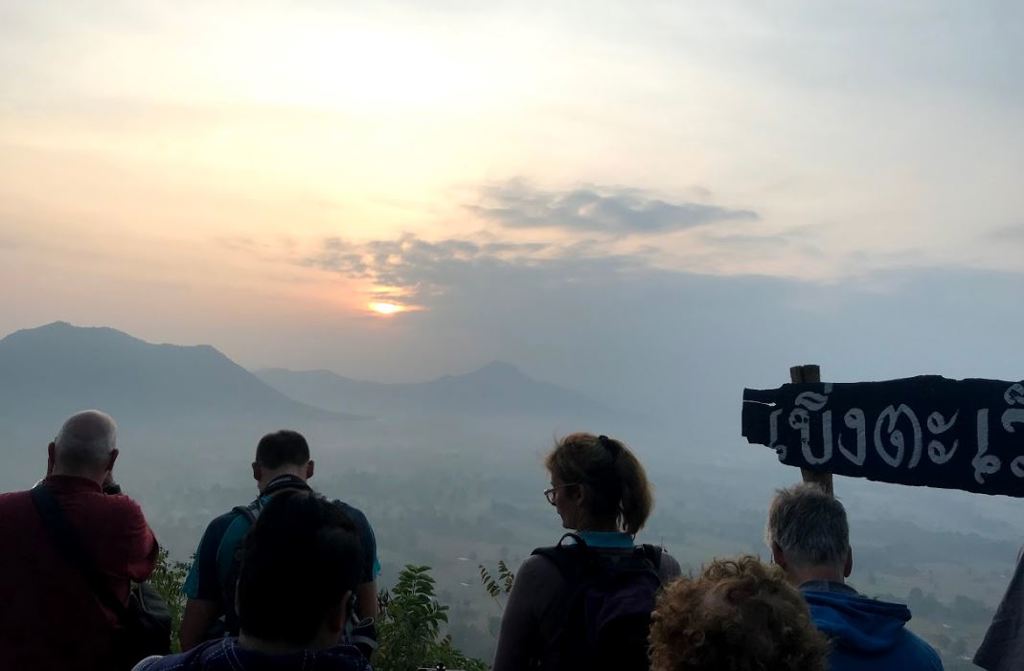 Groepsrondreis Thailand Avontuur: reizigers kijken bij zonsopgang uit over mistige bergen en dalen.