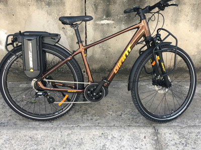 Bronzen Giant e-bike met accu en bagagedrager, geschikt om te huren voor een fietsreis.