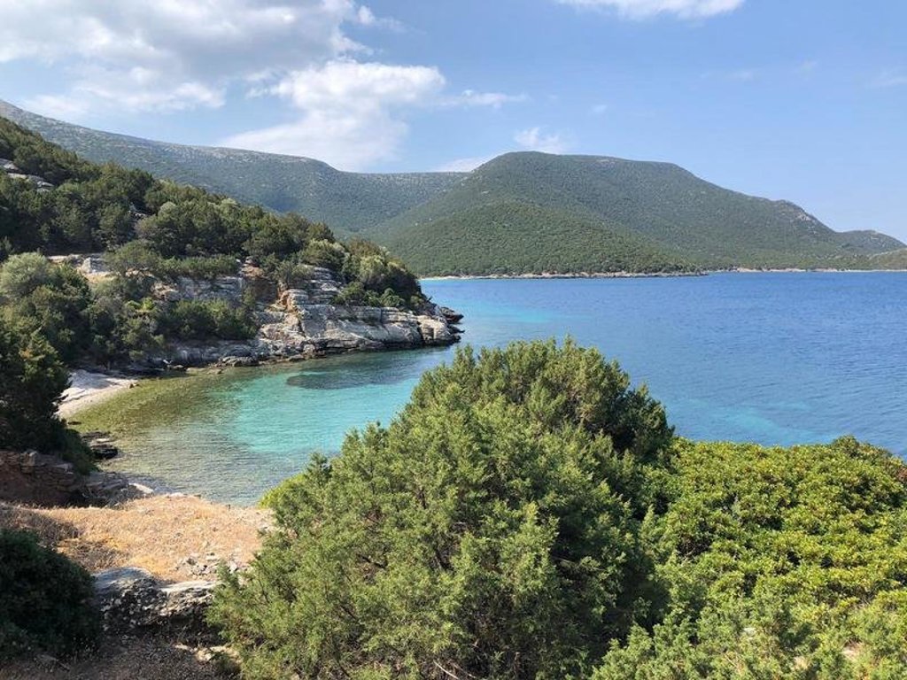 Uitzicht op groene bergen en een dorp op Evia, Griekenland, tijdens een wandelvakantie.