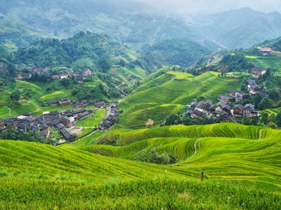 Groene rijstterrassen met dorpjes in de heuvels van China tijdens de Route China, 17 dagen.