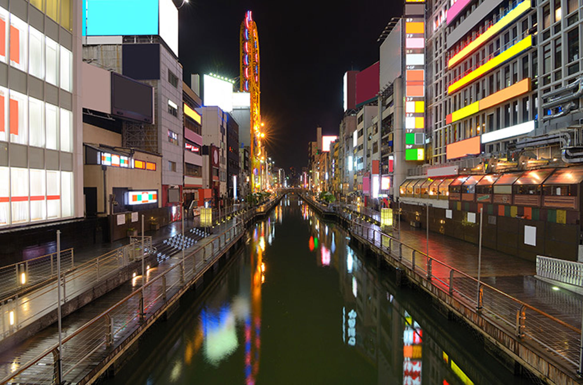 Osaka by night, Japan Verlichte Dotonbori-kanaal in Osaka bij nacht, met neonreclames en reflecties in het water.