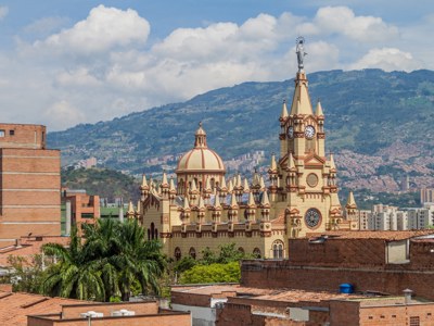 Basiliek van Medellín met klokkentoren en bergen op de achtergrond, Colombia.