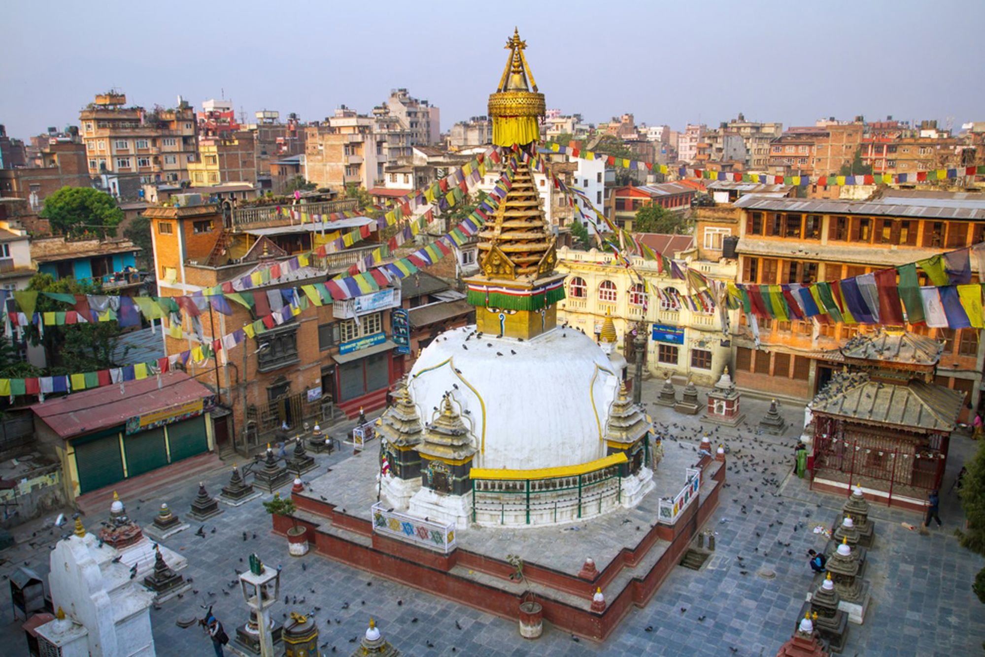 Swayambhunath-stoepa in Kathmandu met gebedsvlaggen en uitzicht over de stad, Nepal.