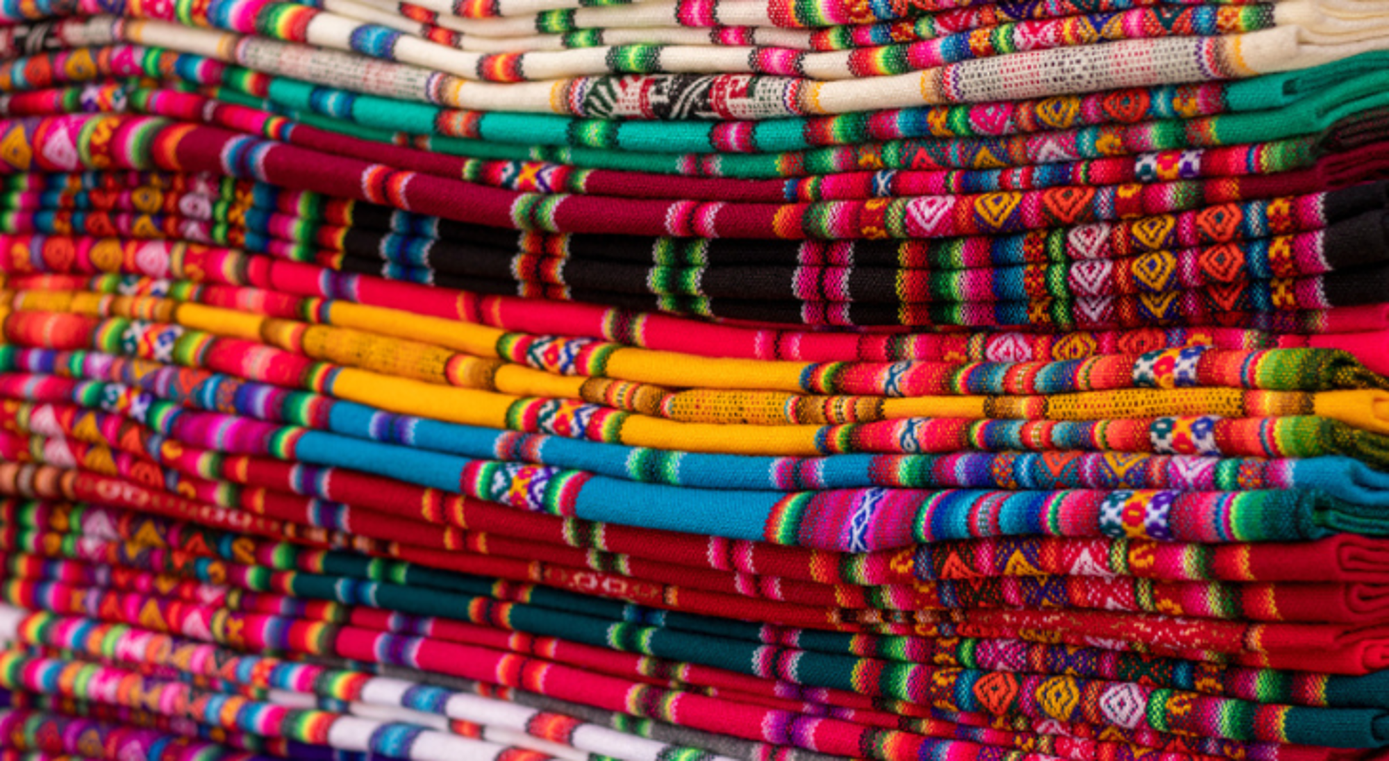 Inca crafts Cochabamba Stapels kleurrijke, geweven textiel met traditionele patronen op een markt in Bolivia.