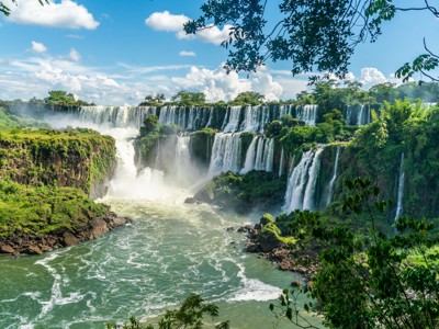 Panorama van de Iguazú-watervallen op de route Brazilië en Buenos Aires, met jungle en nevel boven het water.