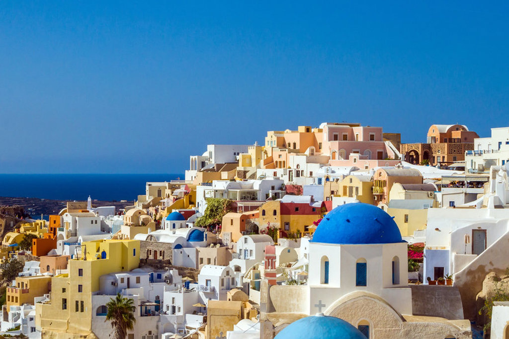 Witte huizen en blauwe koepels in Oia op Santorini, Griekenland, met uitzicht op zee.