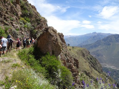 Wandelaars op bergpad langs rotswand met uitzicht op de Andes tijdens Route Peru.