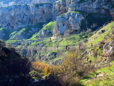 Wandelaars op een hangbrug in de Gravina-kloof bij Matera, tijdens de route Puglia en Matera.