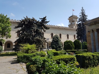 Gevel van het Georgisch Nationaal Museum in Tbilisi, met tuin en Georgische vlag.