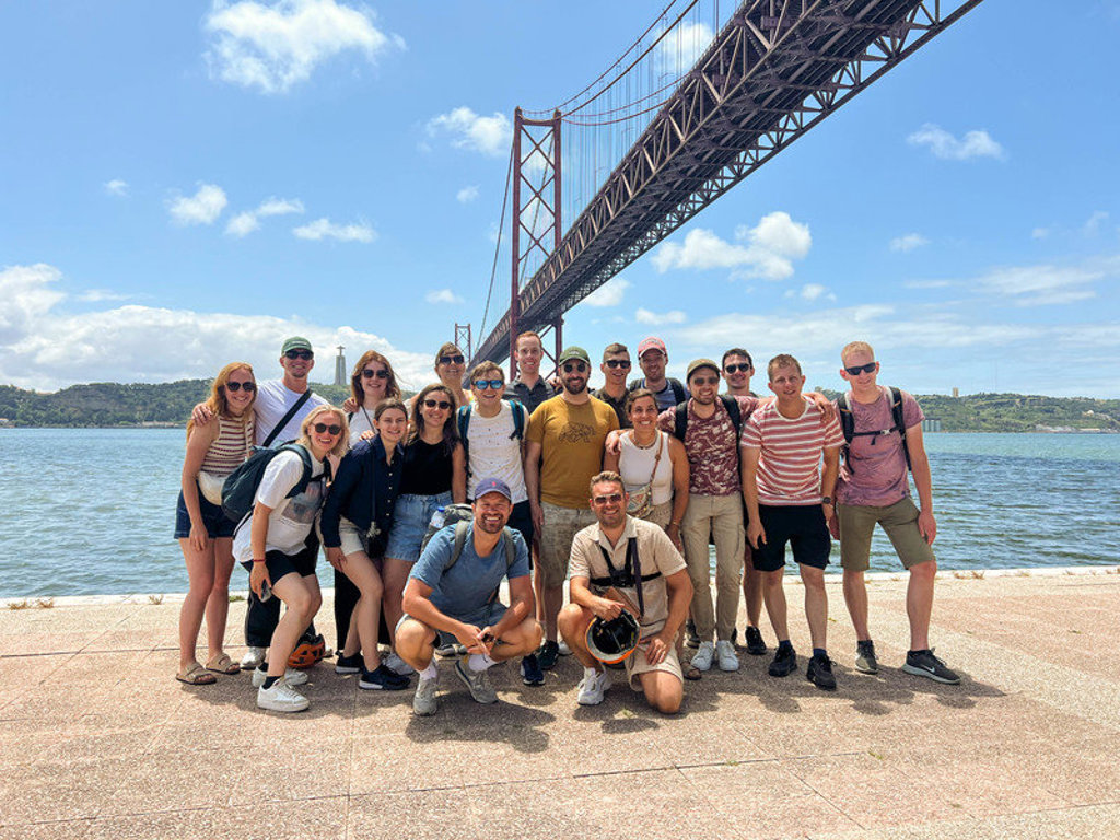 Groepsfoto van 22-35ers reis Madeira & Portugal bij de Ponte 25 de Abril in Lissabon.