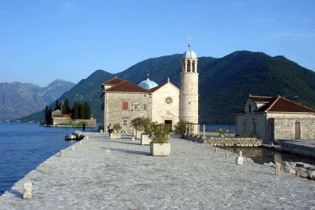 Kerk op een eilandje in de Baai van Kotor, met bergen op de achtergrond tijdens een groepsrondreis Balkan.
