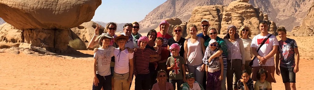 Familiegroep in de Wadi Rum-woestijn in Jordanië tijdens familiereis Israël, Palestijnse gebieden en Jordanië.