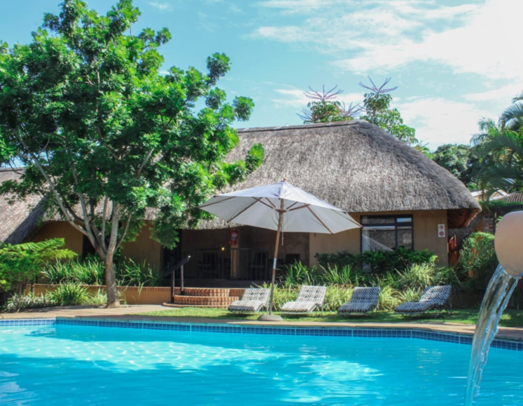 Zwembad bij lodge met rieten dak tijdens Groepsrondreis Zuid-Afrika (Premium).