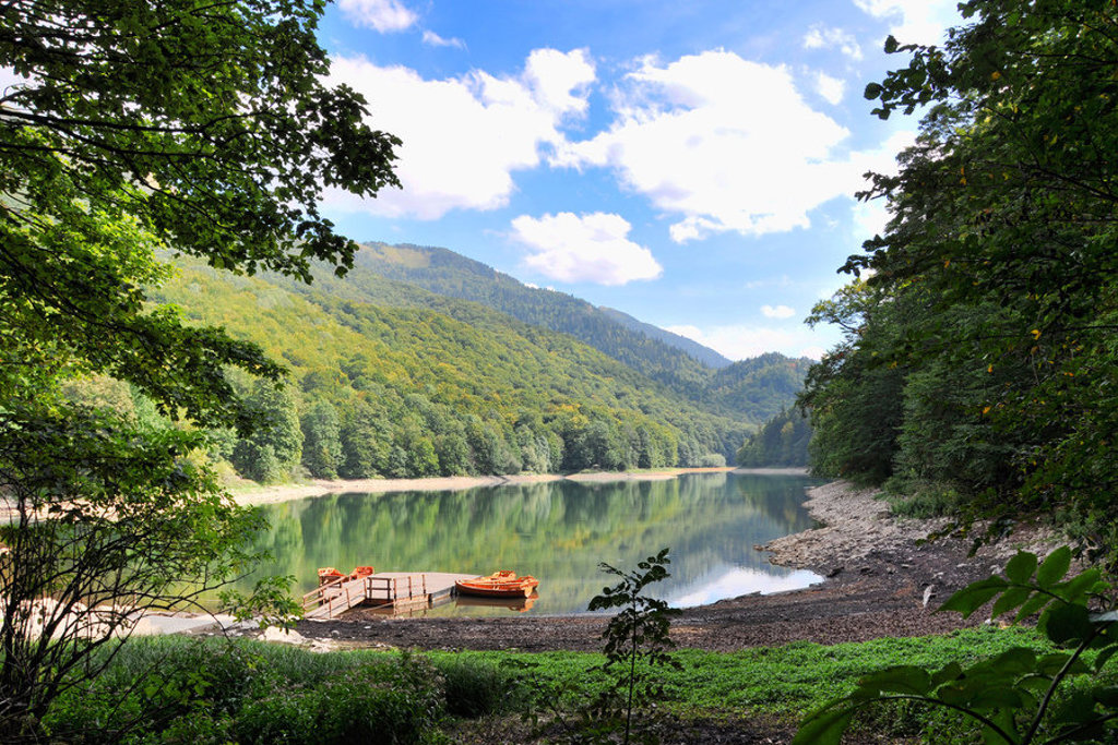 Groen bergmeer met houten steiger en roeiboot, tijdens familiereis Kroatië en Montenegro.