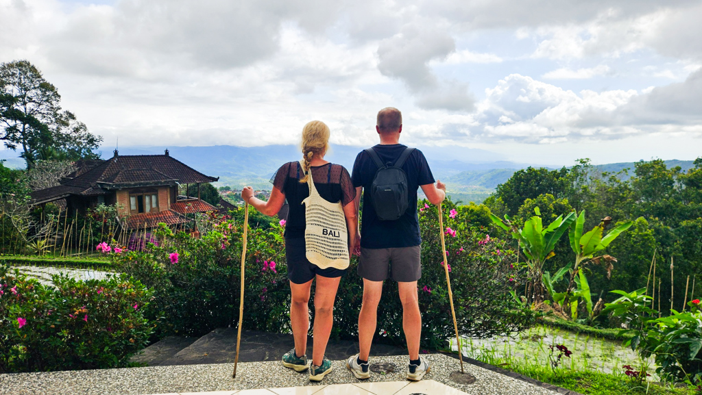 Wandelaars kijken uit over rijstterrassen en bergen op Bali tijdens een familiereis Sumatra, Java en Bali.