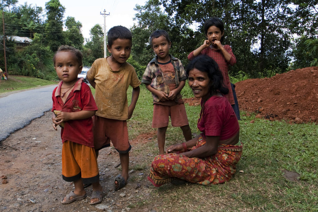 Lokale kinderen en vrouw langs een weg in Nepal tijdens een familiereis.