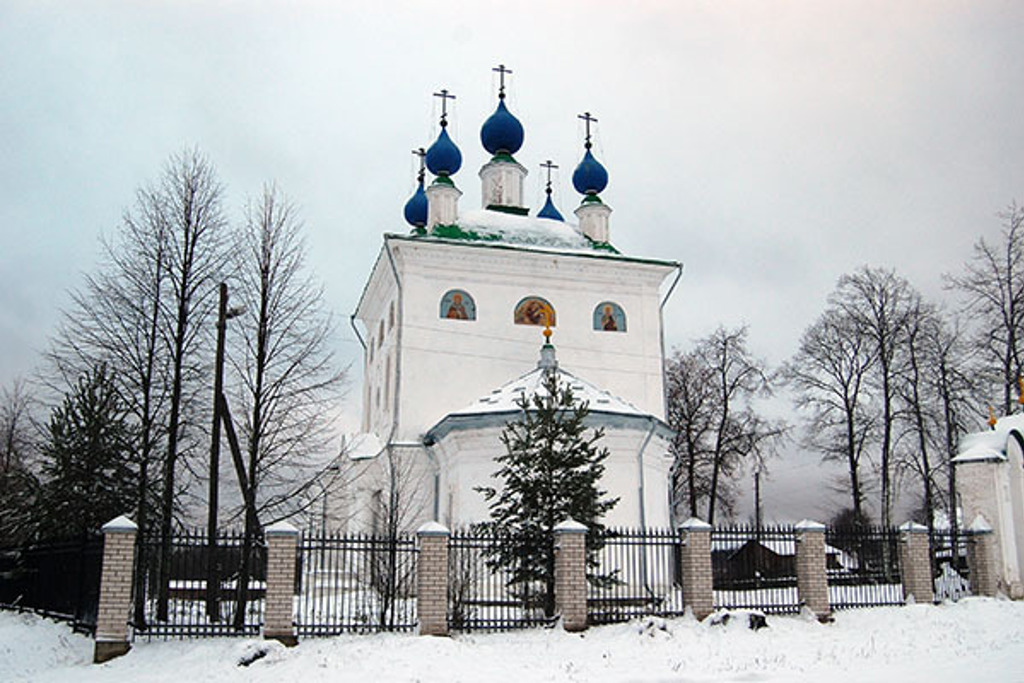 Witte Russisch-orthodoxe kerk met blauwe uivormige koepels in een besneeuwd landschap tijdens de winterrondreis Rusland.