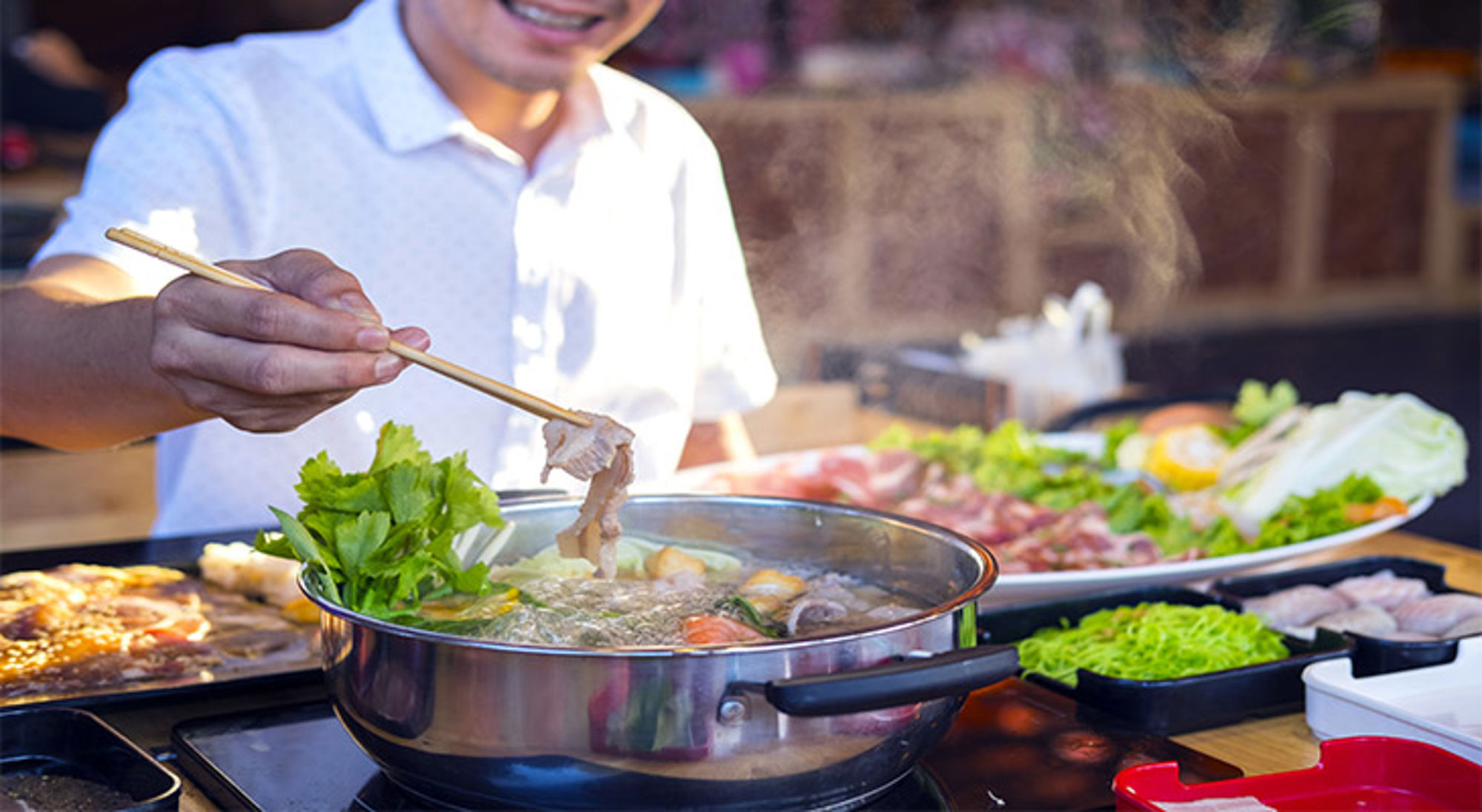 Shabu Shabu in Japan Man bereidt een hete hotpot met vlees en groenten aan tafel in een restaurant.