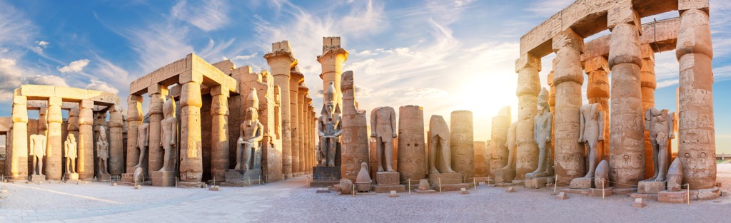 Zuilen en faraobeelden in de tempel van Luxor bij zonsondergang, Egypte.
