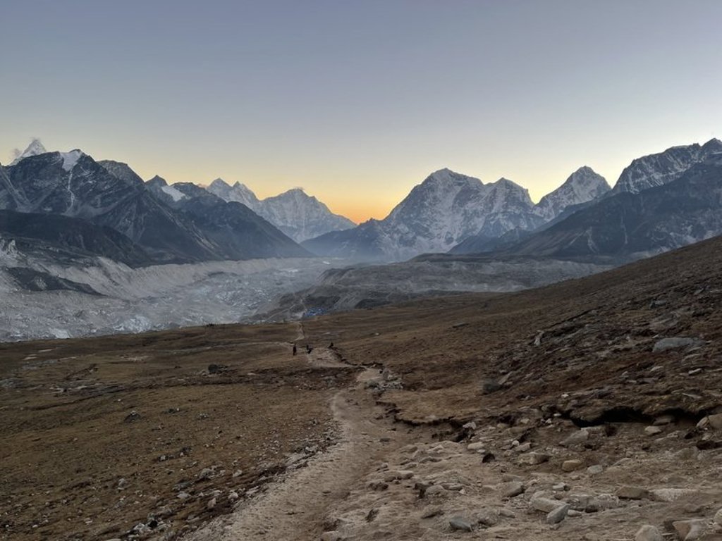Trekker met rugzak loopt op een bergpad in Nepal tijdens de Everest-trektocht.
