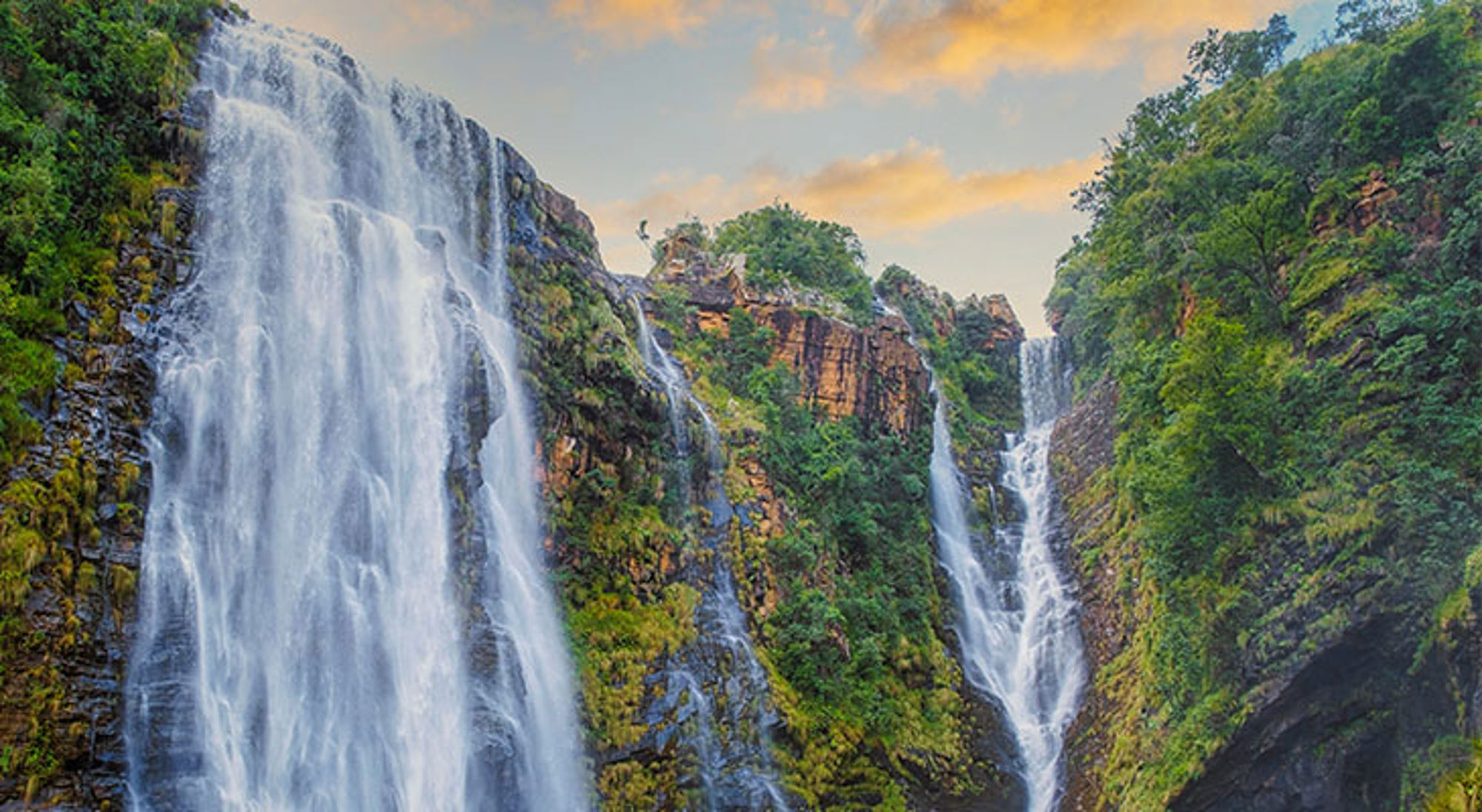 Watervallen dichtbij Gods Window Tugela Falls waterval in de Drakensbergen, Zuid-Afrika, met groene kliffen en een heldere lucht.