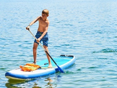 Jongen peddelt staand op een SUP-board op de Río Cinca in Aragón, Spanje.