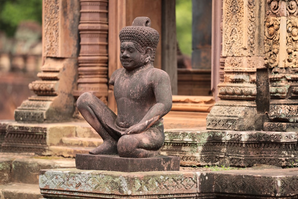 Zittend stenen beeld bij een tempelcomplex tijdens fietsvakantie Vietnam, Cambodja en Thailand.