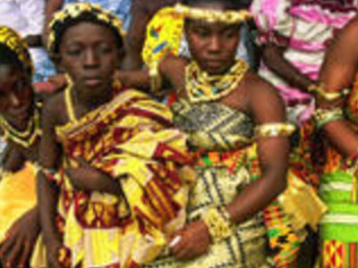 Vrouwen in kleurrijke traditionele kledij en hoofdtooien tijdens een ceremonie in Ghana, Togo of Benin.
