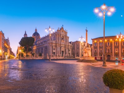 Verlichte Piazza del Duomo in Catania, Sicilië, bij schemering met de kathedraal en fontein.