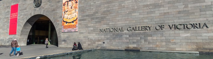 Entree van de National Gallery of Victoria in Melbourne met vijver en gevel met museumnaam.