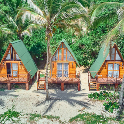 Glamping hutten voor 1 of 2 personen op het strand tussen palmbomen.