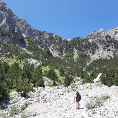 Wandelaar in de Albanese Alpen tijdens Wandelvakantie Peaks of the Balkan, met ruige bergtoppen op de achtergrond.