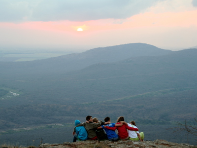 Reizigers kijken bij zonsondergang uit over de bergen tijdens de Route Zuid-Afrika.