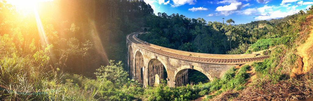 Spoorbrug met negen bogen bij Ella, Sri Lanka, omringd door groene heuvels in de ochtendzon.