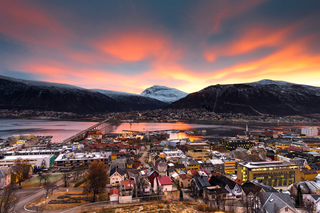 Uitzicht over Bodø met brug en fjord bij zonsondergang, startpunt van de groepsrondreis naar Noord-Noorwegen en Spitsbergen.