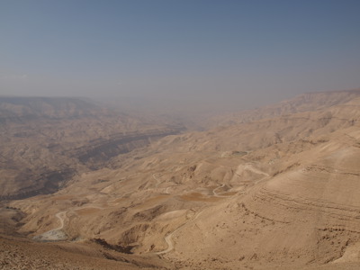 Uitzicht over de woestijnheuvels en kronkelende wegen bij de Dode Zee in Jordanië en Israël.