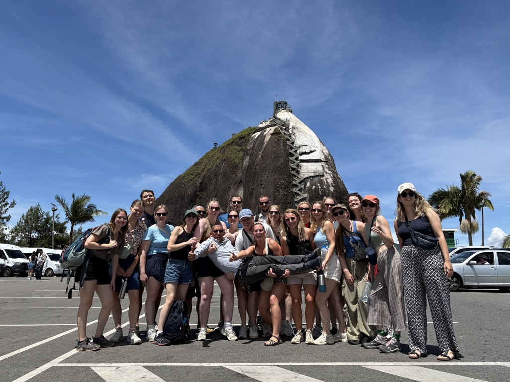 Groepsfoto van 22-35ers tijdens rondreis Colombia bij El Peñón de Guatapé (La Piedra del Peñol).