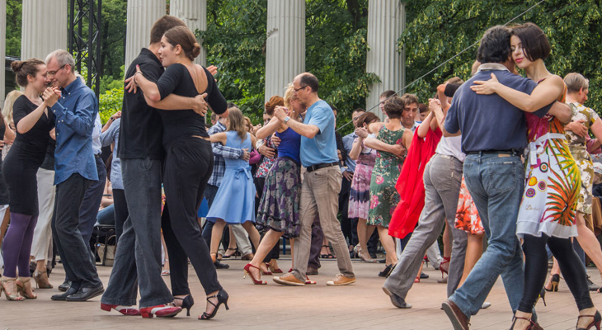Tango dansende mensen in Buenos Aires Dansende stellen bij een tango-evenement in een park met zuilen op de achtergrond.