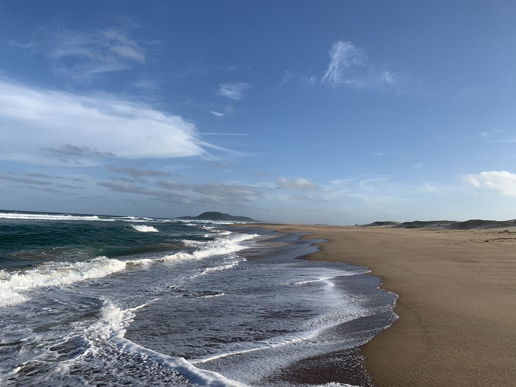 Lege zandstrand met brekende golven aan de kust van Zuid-Afrika tijdens een 22-35ers rondreis.