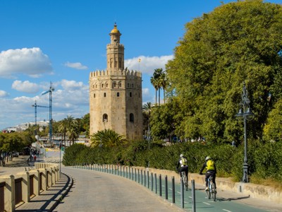Torre del Oro aan de rivier in Sevilla, met fietsers op het pad tijdens de familiereis Spanje & Portugal.
