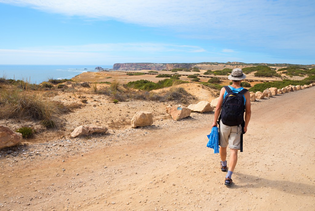 Wandelaar op kustpad langs de Costa Vicentina in Portugal, met uitzicht op zee en kliffen in Alentejo en Algarve.