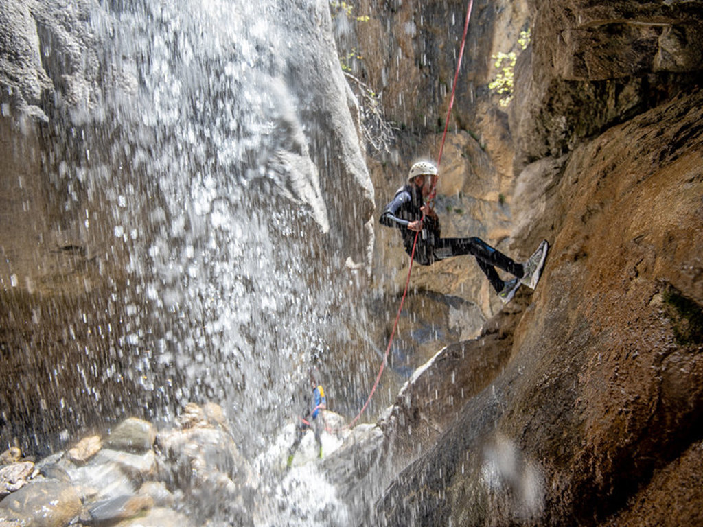 Canyoning bij een waterval in Nationaal Park Écrins, Frankrijk, tijdens een familiereis met camping.