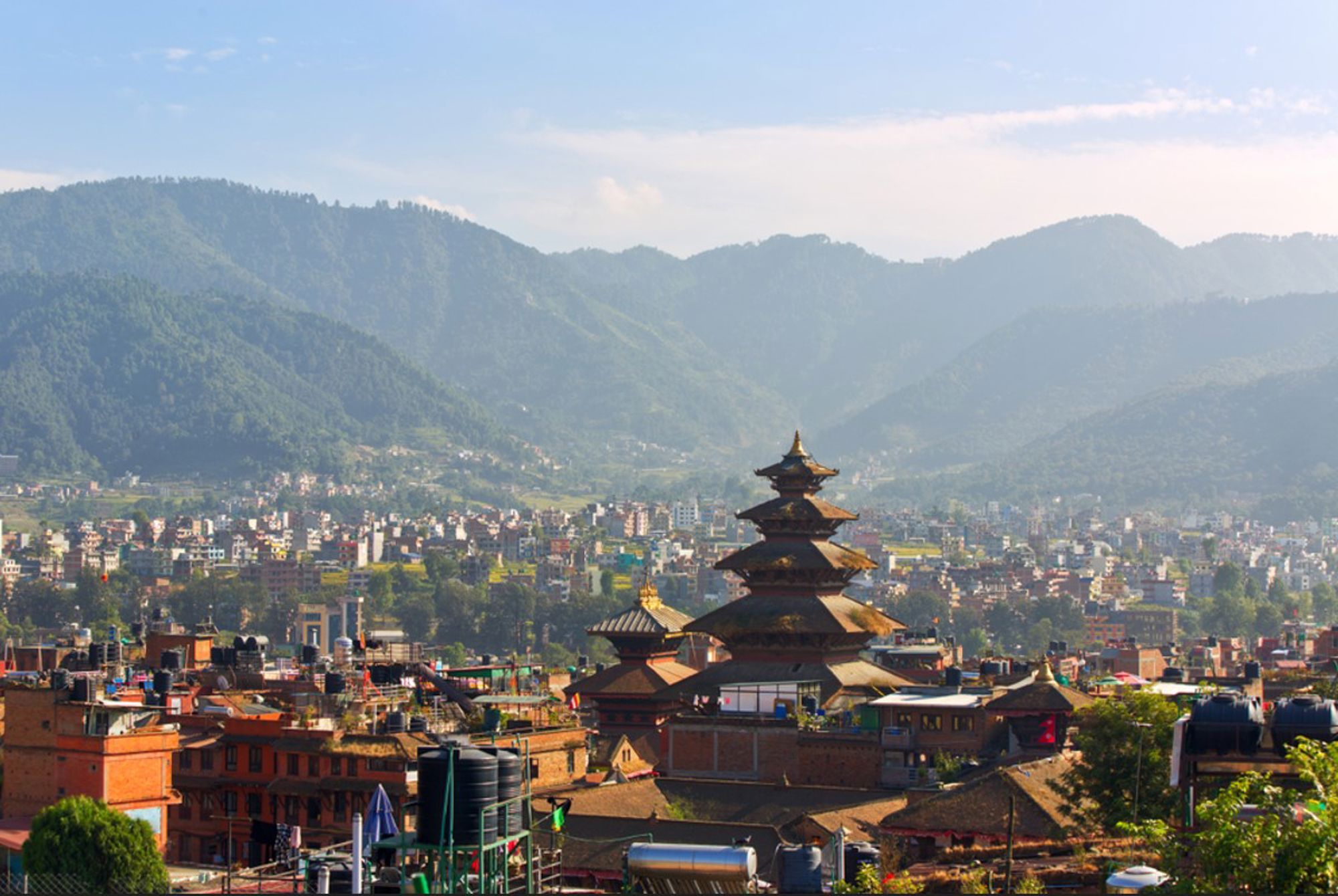 Uitzicht op Kathmandu-vallei met pagodetempel en de groene heuvels van Nepal op de achtergrond.