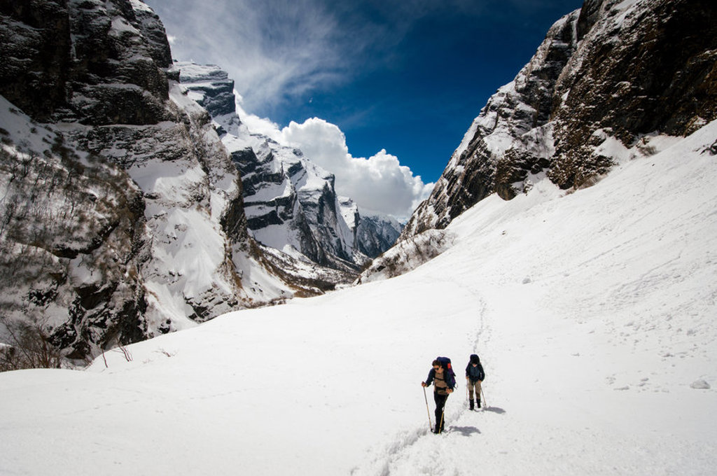 Trektocht naar Annapurna Basecamp in Nepal, wandelaars in een besneeuwd Himalaya-dal.