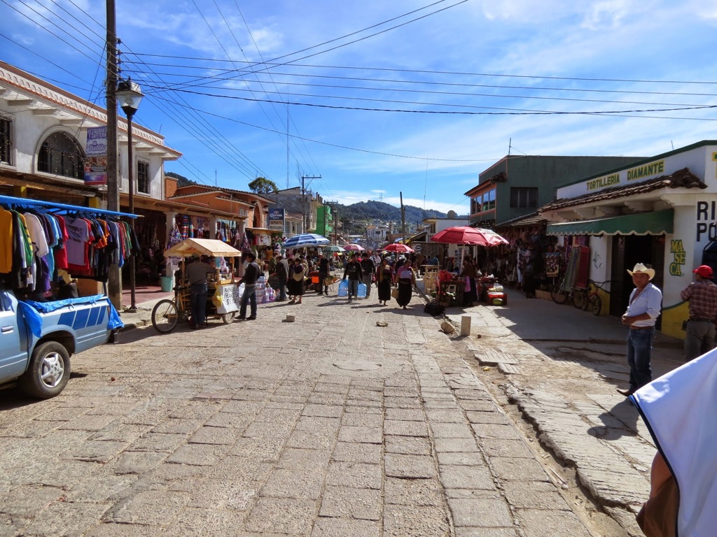 Drukke marktstraat in Mexico met kraampjes en kleurrijke parasols, tijdens een familiereis Mexico.