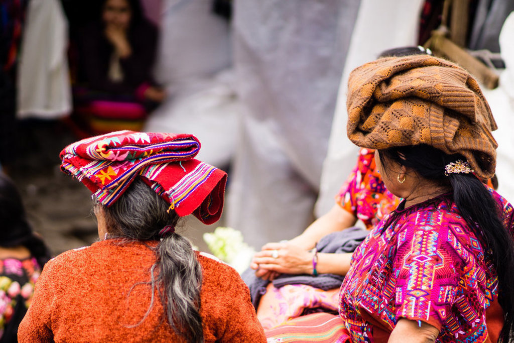 Vrouwen in kleurrijke traditionele kleding op een markt in Guatemala tijdens een groepsrondreis.